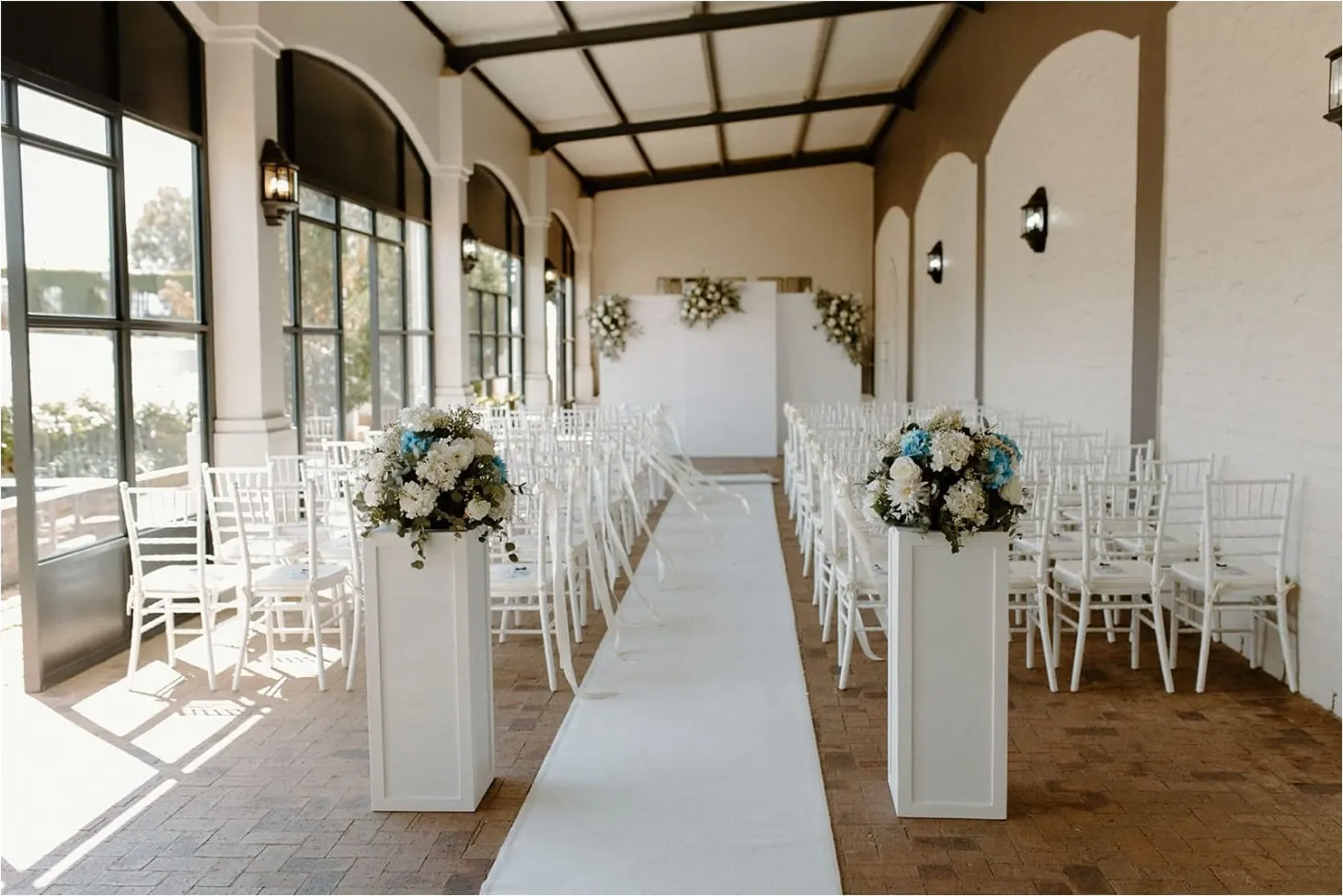 Wedding aisle styled with white square plinths and flowers